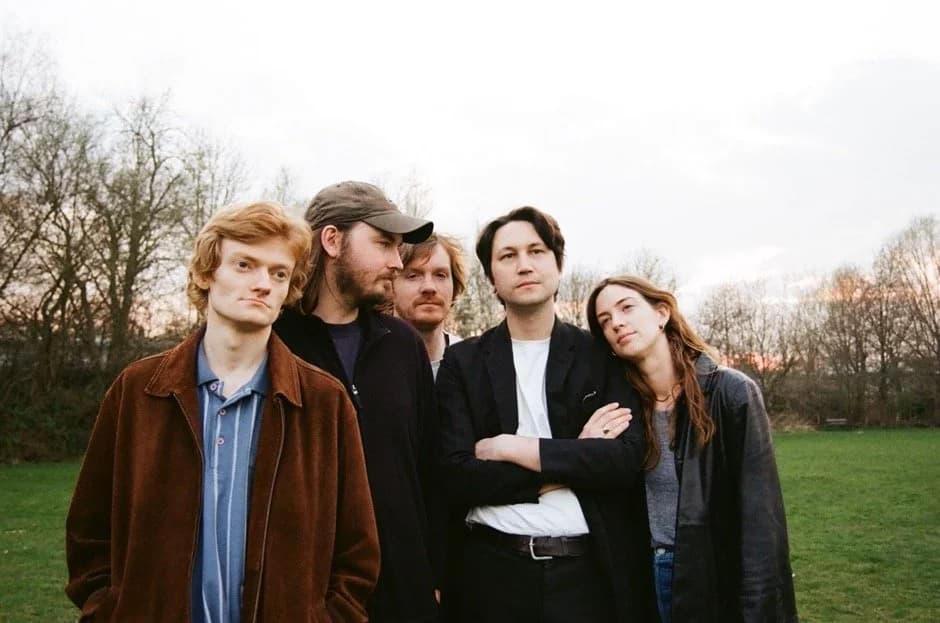 Gently Tender band portrait outdoors at dusk in a park setting.