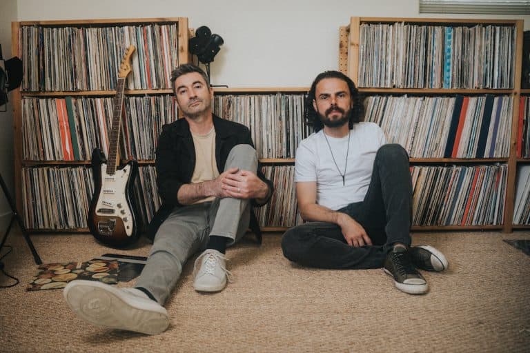 Ships Have Sailed — Will Carpenter and Art Andranikyan sitting on the floor in front of a wall of vinyl records.