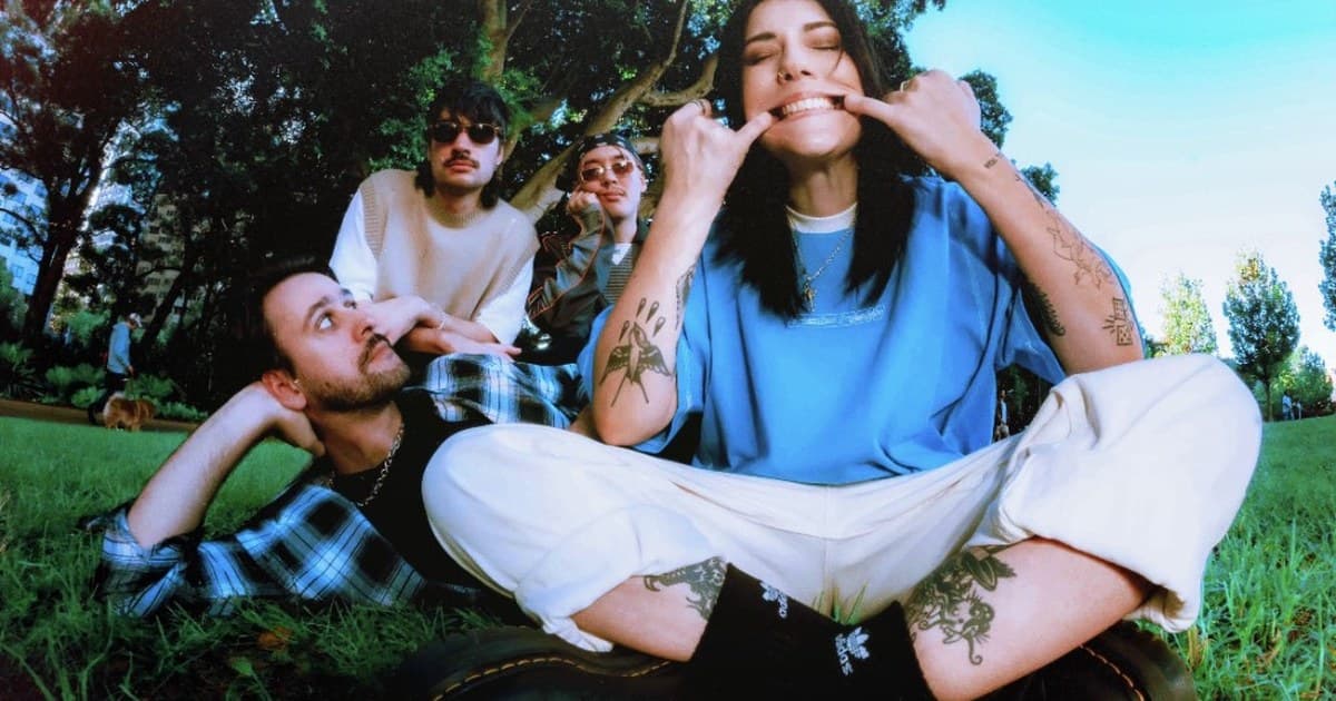 Stand Atlantic photographed with a fisheye lens sitting in a sunny park, vocalist Bonnie Fraser front and center pulling a playful face.